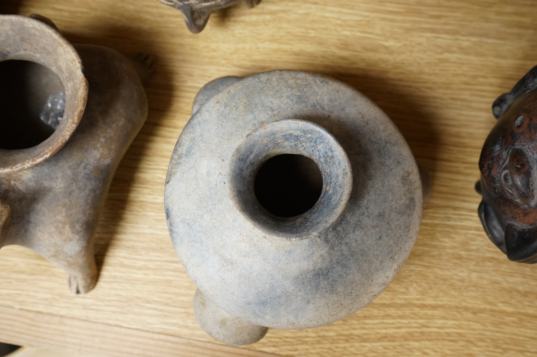 A collection of various South American vessels some in the form of grotesque heads, largest 24cm wide